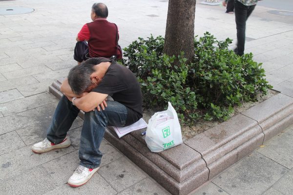 有兩個人坐在低矮的花圃旁