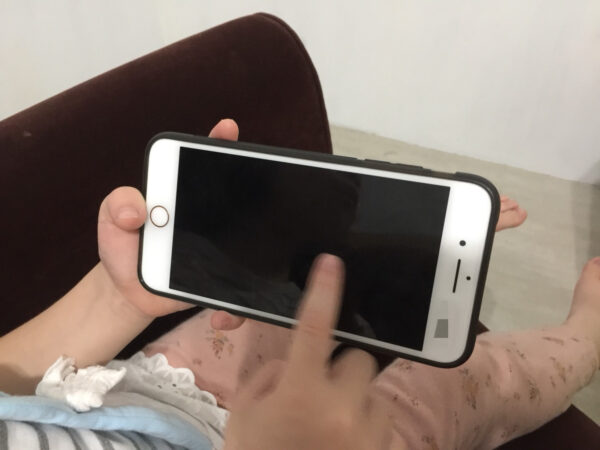 小朋友正用手指滑動手機螢幕